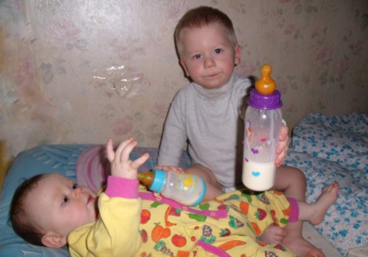 Elijas dalijosi skaniu pieno gėrimu su broliuku